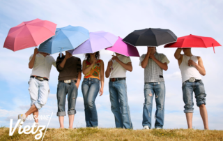 mehrere Menschen mit SChirm in Sonne Vietz